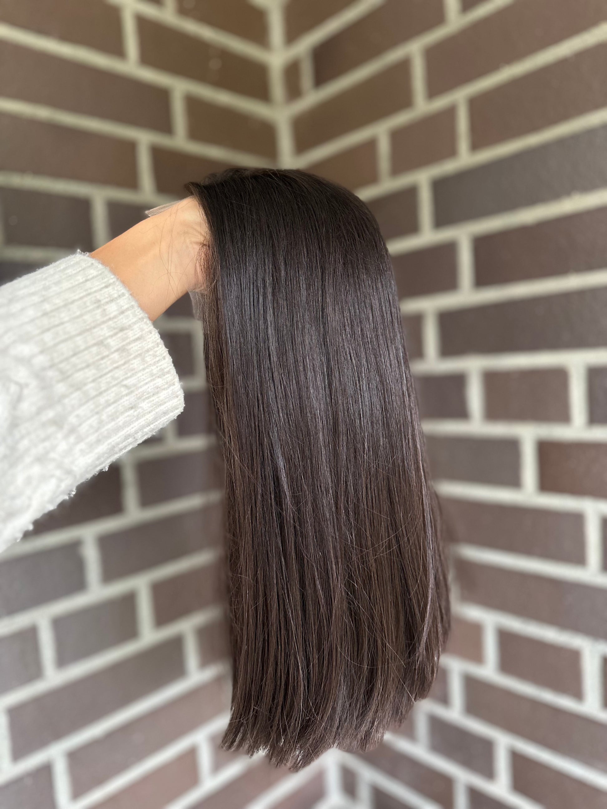Bild zeigt blondes Echthaarteil, das seitlich ins Bild gehalten wird. Bild dient der Produktpräsentation eines Artikels in der Kategorie Topper/Perücken.