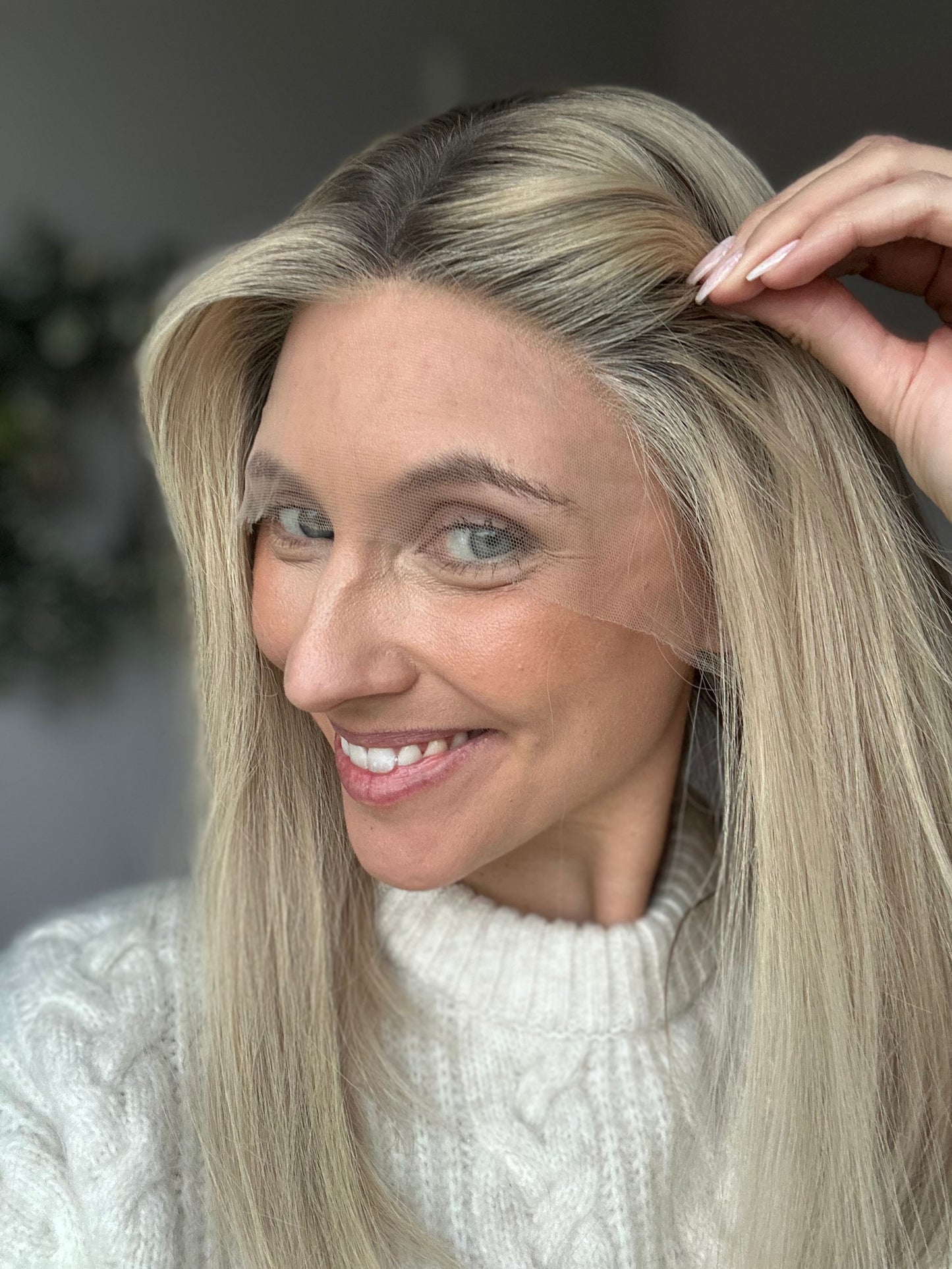 Bild zeigt attraktive Frau, die ihren Kopf leicht beugt, sodass blonder Haaransatz sichtbar wird. Bild dient der Produktpräsentation eines Artikels in der Kategorie Topper/Perücken.