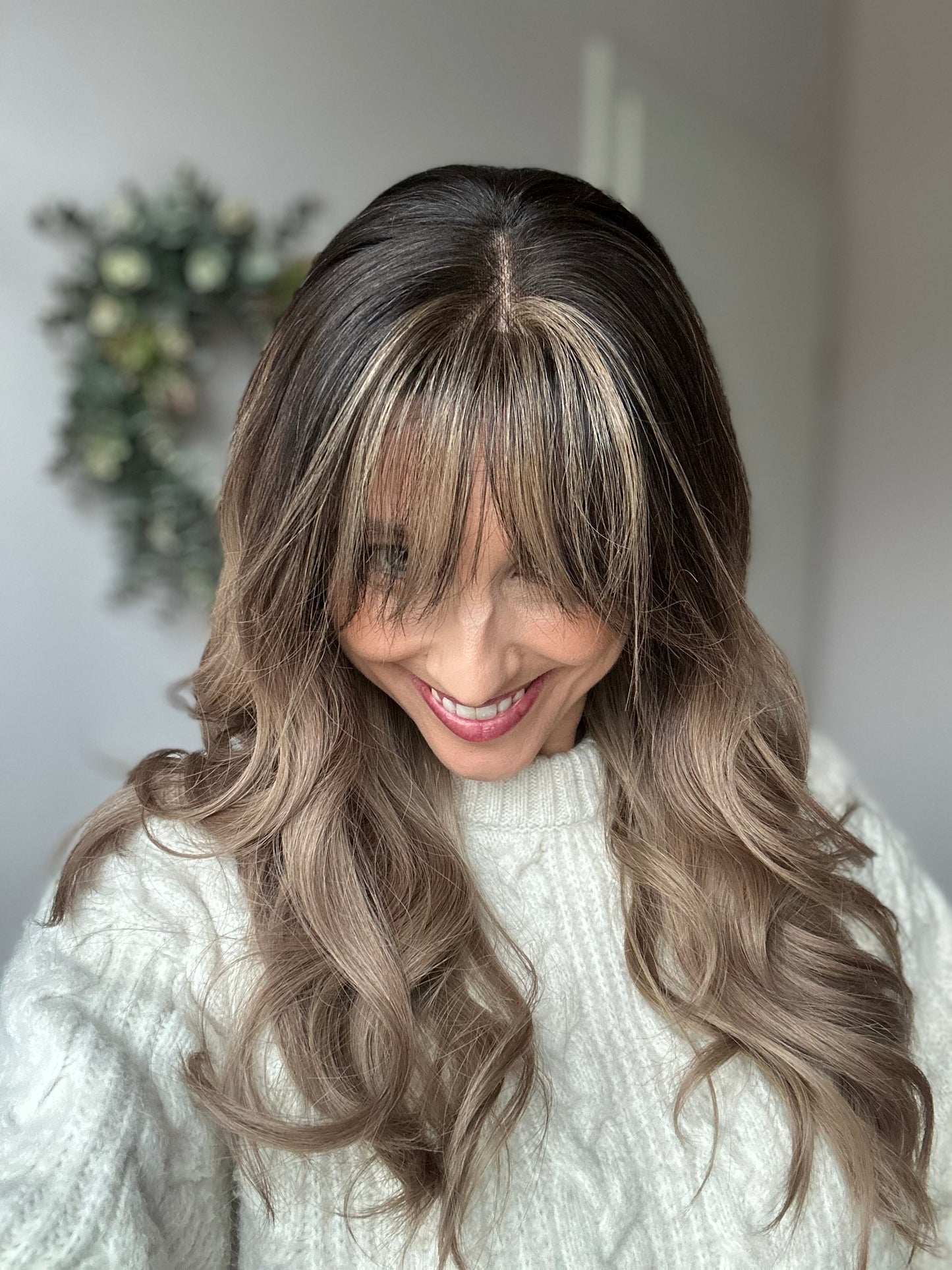 Bild zeigt attraktive Frau, die ihren Kopf leicht beugt, sodass blonder Haaransatz sichtbar wird. Bild dient der Produktpräsentation eines Artikels in der Kategorie Topper/Perücken.