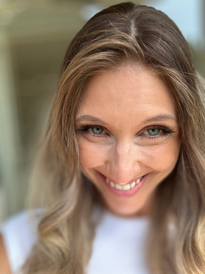 Bild zeigt attraktive Frau, die ihren Kopf leicht beugt, sodass blonder Haaransatz sichtbar wird. Bild dient der Produktpräsentation eines Artikels in der Kategorie Topper/Perücken.