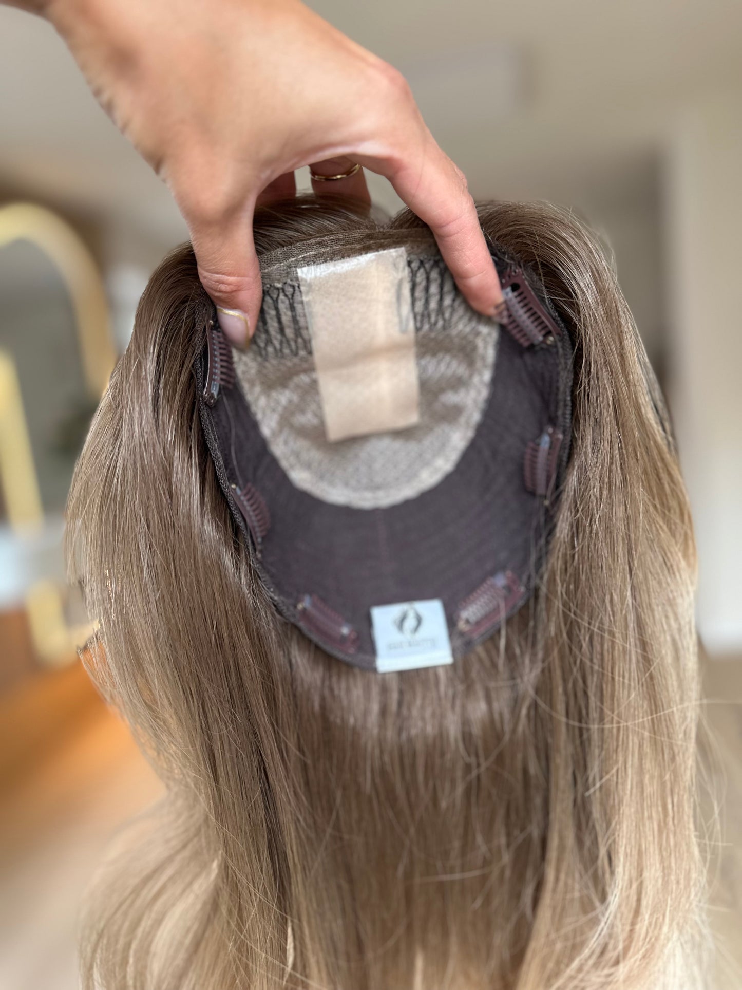 blondes Echthaarteil wird frontal im Video gezeigt. Video dient der Produktpräsentation eines Artikels in der Kategorie Topper/Perücken.