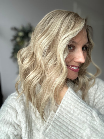 Bild zeigt attraktive Frau von der Seite, mit schulterlangem blondem Haar. Bild dient der Produktpräsentation eines Artikels in der Kategorie Topper/Perücken.