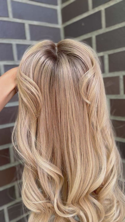 Video zeigt blondes Echthaarteil, das frontal ins Bild gehalten wird. Bild dient der Produktpräsentation eines Artikels in der Kategorie Topper/Perücken.