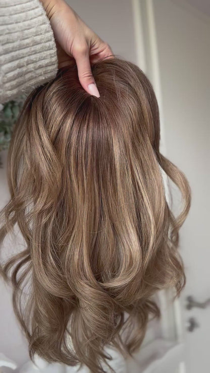 blondes Echthaarteil wird frontal im Video gezeigt. Video dient der Produktpräsentation eines Artikels in der Kategorie Topper/Perücken.