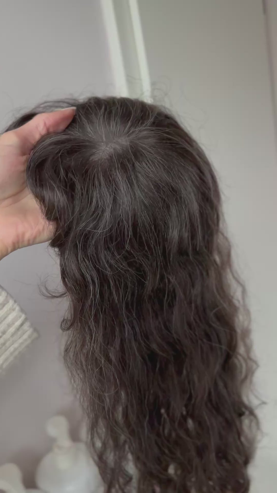 braunes Echthaarteil wird frontal im Video gezeigt. Video dient der Produktpräsentation eines Artikels in der Kategorie Topper/Perücken.