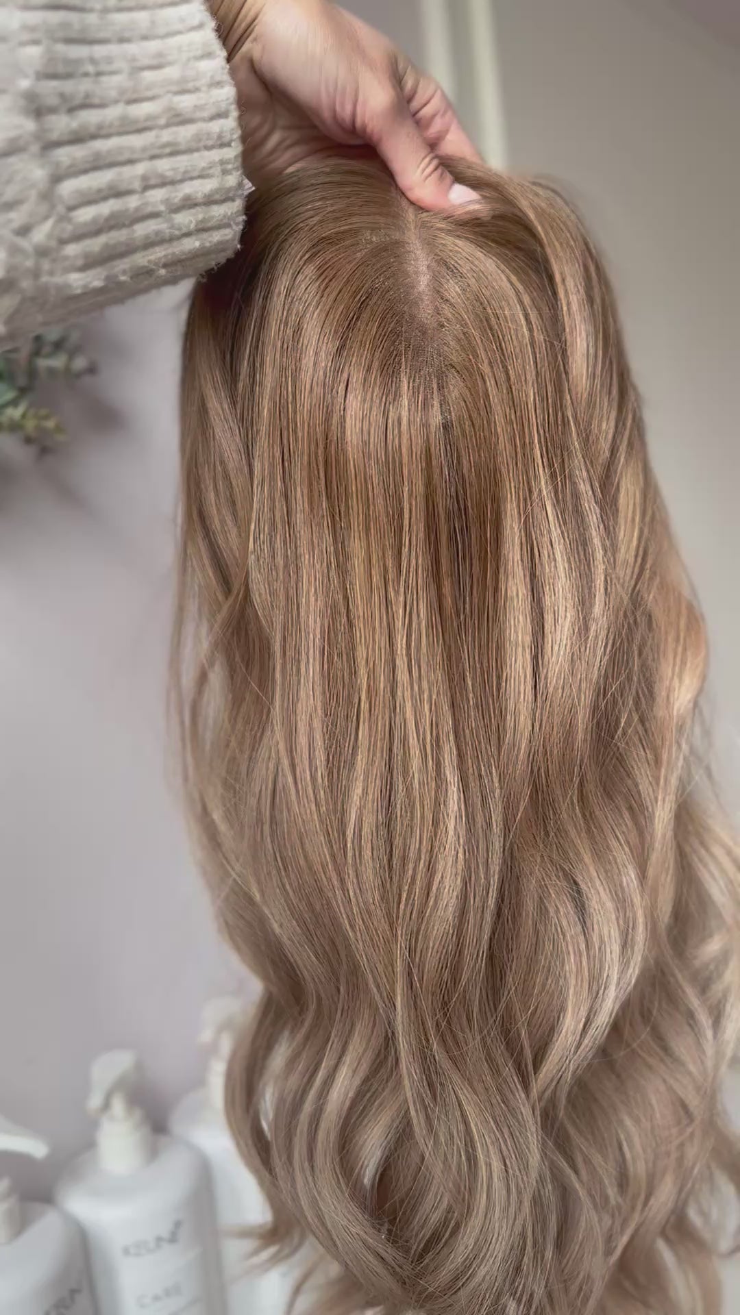 blondes Echthaarteil wird frontal im Video gezeigt. Video dient der Produktpräsentation eines Artikels in der Kategorie Topper/Perücken.