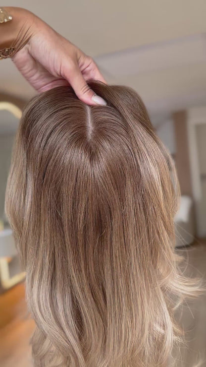 blondes Echthaarteil wird frontal im Video gezeigt. Video dient der Produktpräsentation eines Artikels in der Kategorie Topper/Perücken.