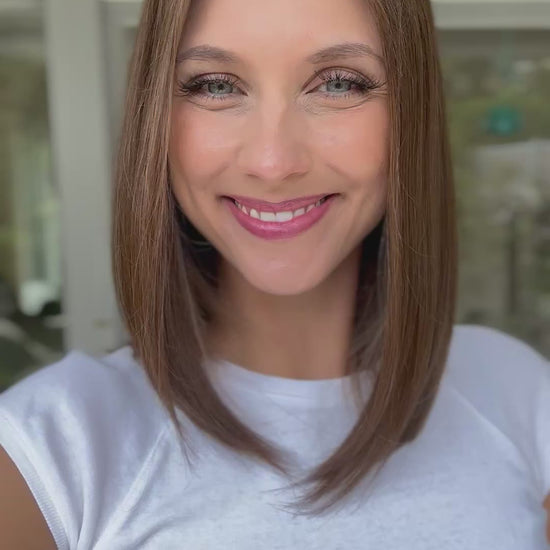 Video zeigt attraktive Frau mit schulterlangem braunem Haar. Video dient der Produktpräsentation eines Artikels in der Kategorie Topper/Perücken.
