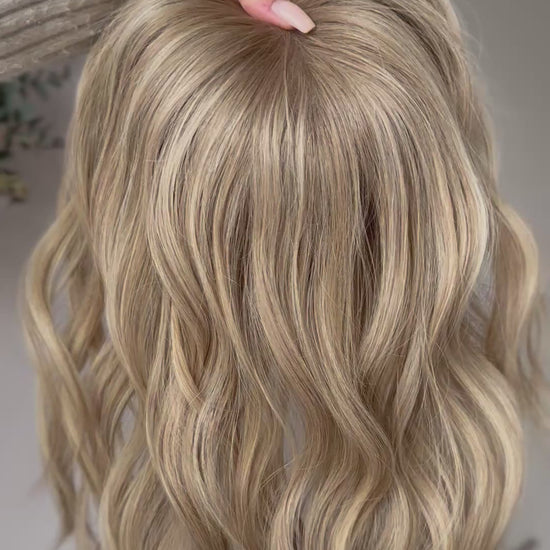 blondes Echthaarteil wird frontal im Video gezeigt. Video dient der Produktpräsentation eines Artikels in der Kategorie Topper/Perücken.